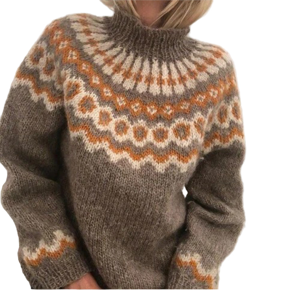 Femme portant un pull en tricot épais à col montant, de couleur beige avec des motifs géométriques dans des tons marron, orange et blanc. Le vêtement dégage une allure cosy et élégante, parfaite pour la saison hivernale.