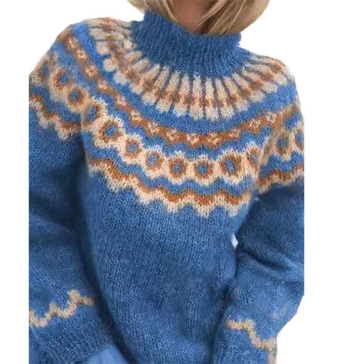 Femme portant un pull épais à col montant en maille moelleuse de couleur bleue. Le pull présente un motif nordique géométrique en beige, blanc et orange sur le haut et les manches, offrant un look cosy, chaud et élégant, idéal pour la saison hivernale.