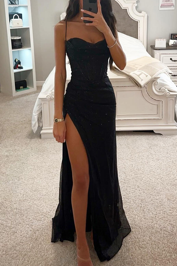 Elégante en tissu noir scintillant, coupe moulante avec fines bretelles et fente haute, idéale pour une soirée chic ou un événement spécial.