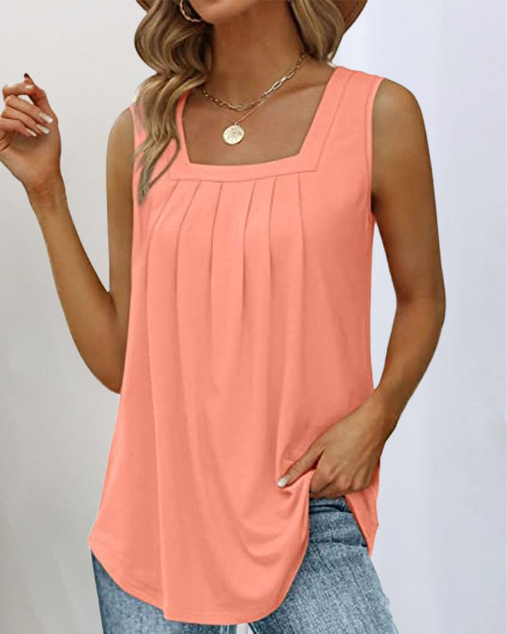 Débardeur femme Carrington couleur corail avec col carré, coupe moderne fluide et sans manches, détails plissés sur le devant, porté avec un jean.