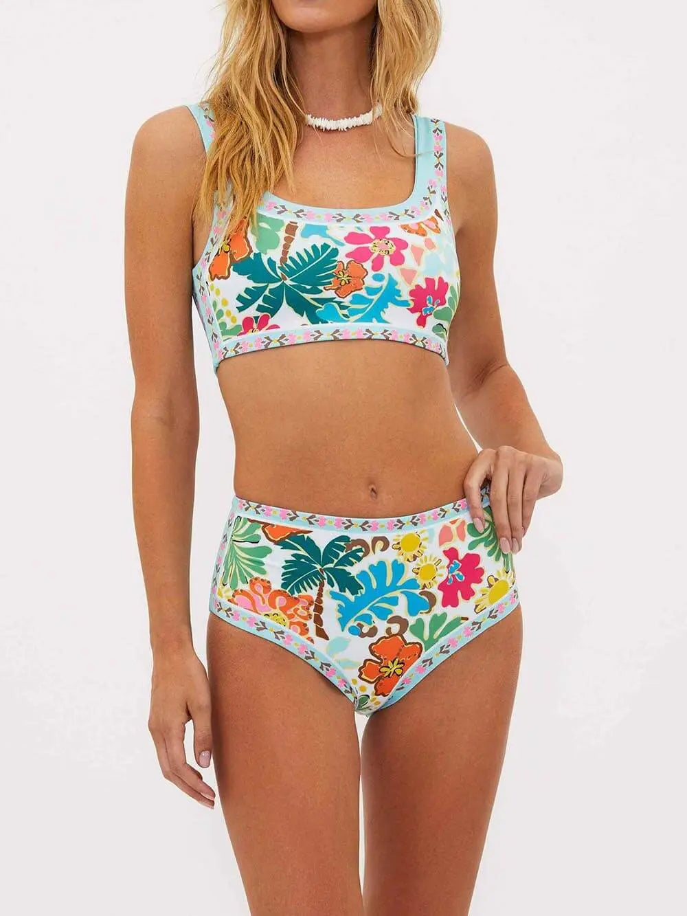Bikini floral stretch pour femme, modèle Cassandre. Haut à bretelles et bas taille haute, ornés de motifs floraux vibrants sur un fond clair. Design moderne et coloré, parfait pour les journées estivales à la plage.
