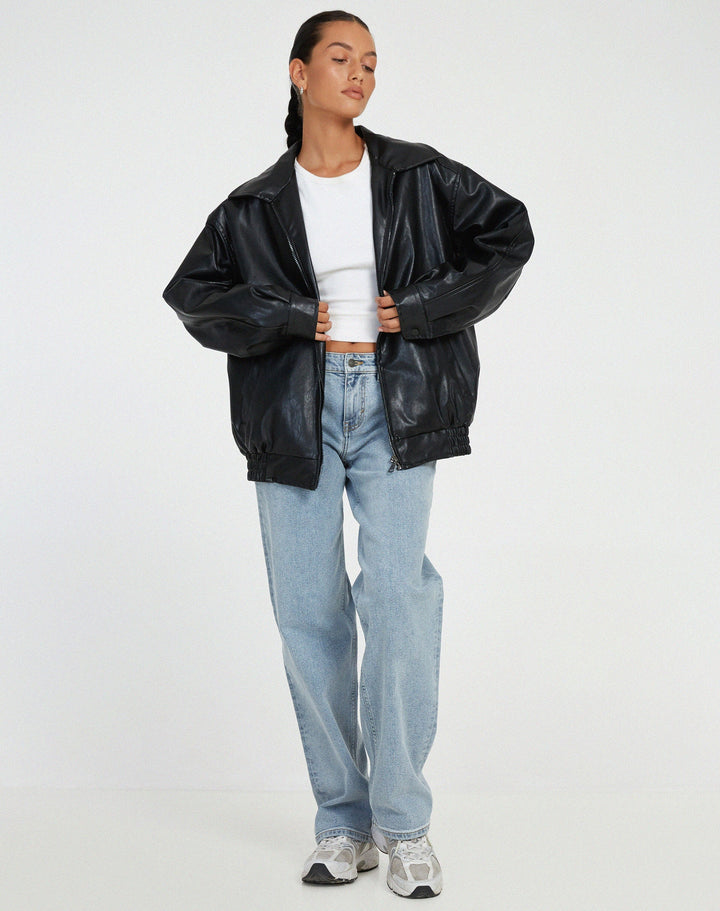 Veste oversize en PU pour femme, modèle Cécile. Veste en simili-cuir noir à la coupe ample, portée avec un t-shirt blanc et un jean décontracté. Un look moderne et stylé, parfait pour l'hiver.