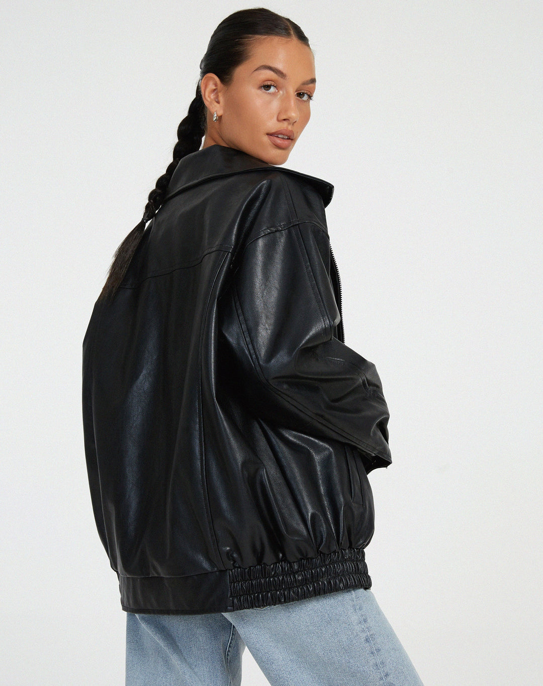 Vue arrière de la veste oversize en PU pour femme, modèle Cécile. Veste en simili-cuir noir avec coupe ample et taille élastiquée, portée avec un jean décontracté. Un look moderne et stylé pour l'hiver.