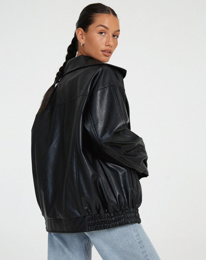 Vue arrière de la veste oversize en PU pour femme, modèle Cécile. Veste en simili-cuir noir avec coupe ample et taille élastiquée, portée avec un jean décontracté. Un look moderne et stylé pour l'hiver.