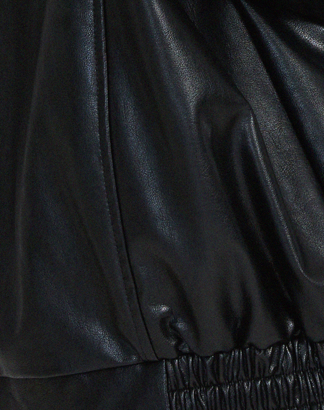 Détail de la veste oversize en PU pour femme, modèle Cécile. Zoom sur la finition de la taille élastiquée en simili-cuir noir, soulignant le style ample et décontracté de la veste, idéale pour l'hiver.