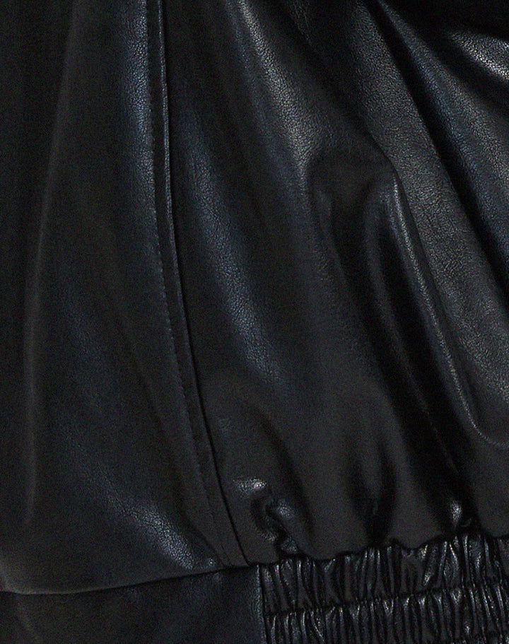 Détail de la veste oversize en PU pour femme, modèle Cécile. Zoom sur la finition de la taille élastiquée en simili-cuir noir, soulignant le style ample et décontracté de la veste, idéale pour l'hiver.