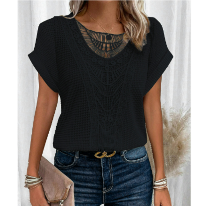 Haut d’été femme Cerise tendance, top noir à manches courtes avec détail en dentelle ajourée au col, porté avec jean bleu et accessoires argentés.