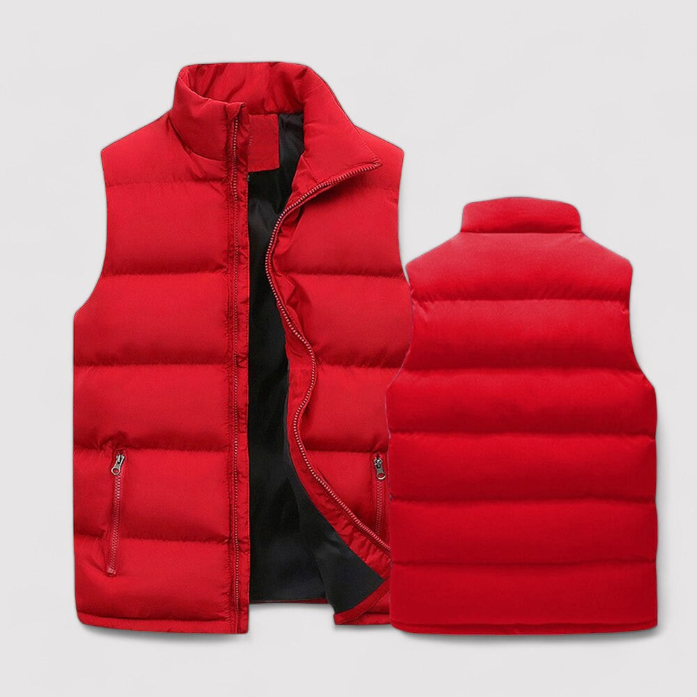 Gilet sans manches pour homme, rembourré et matelassé de couleur rouge vif. Il dispose d'une fermeture éclair centrale, de poches latérales zippées, et d'un col haut pour plus de chaleur et de confort durant l'hiver.