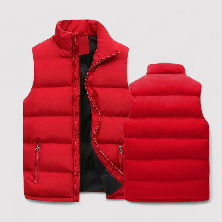 Gilet sans manches pour homme, rembourré et matelassé de couleur rouge vif. Il dispose d'une fermeture éclair centrale, de poches latérales zippées, et d'un col haut pour plus de chaleur et de confort durant l'hiver.