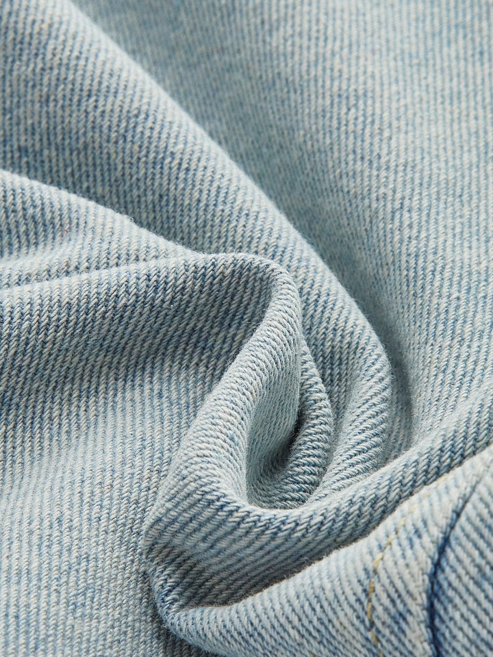Détail du tissu en denim bleu clair, doux au toucher et de haute qualité, qui compose cette veste courte. Le tissu apporte confort et style tout en étant parfait pour la saison hivernale.
