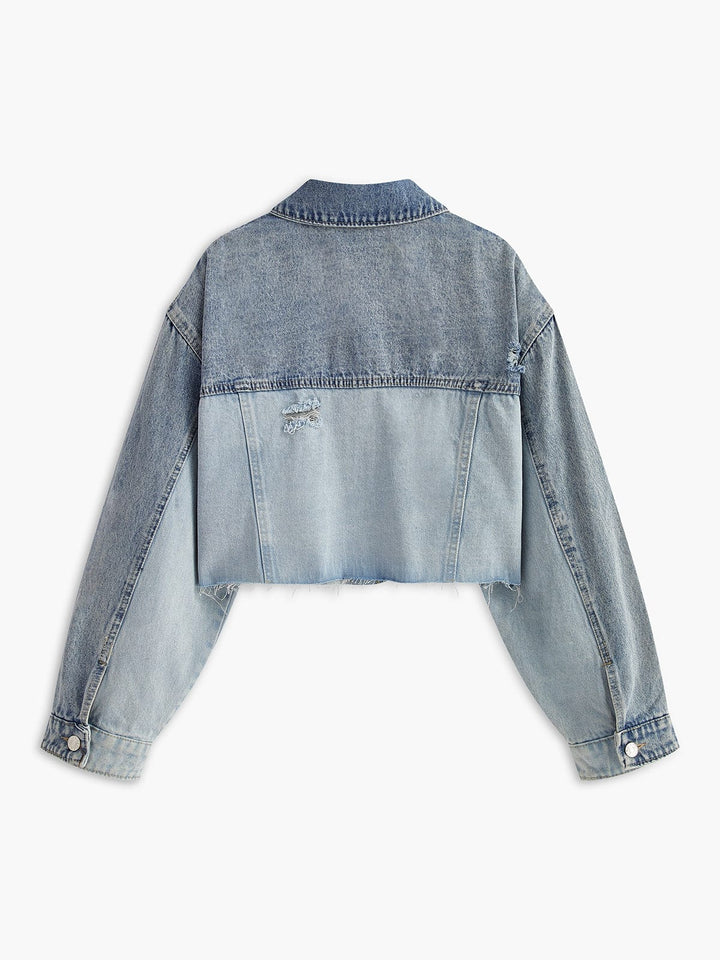 Vue arrière de la veste en jean courte pour femme Clementine, avec un dégradé de bleu clair à bleu foncé. La coupe courte et les détails effilochés au bas de la veste ajoutent une touche moderne et décontractée. Ce modèle minimaliste et tendance est idéal pour un look casual chic, facile à associer avec divers styles de vêtements.