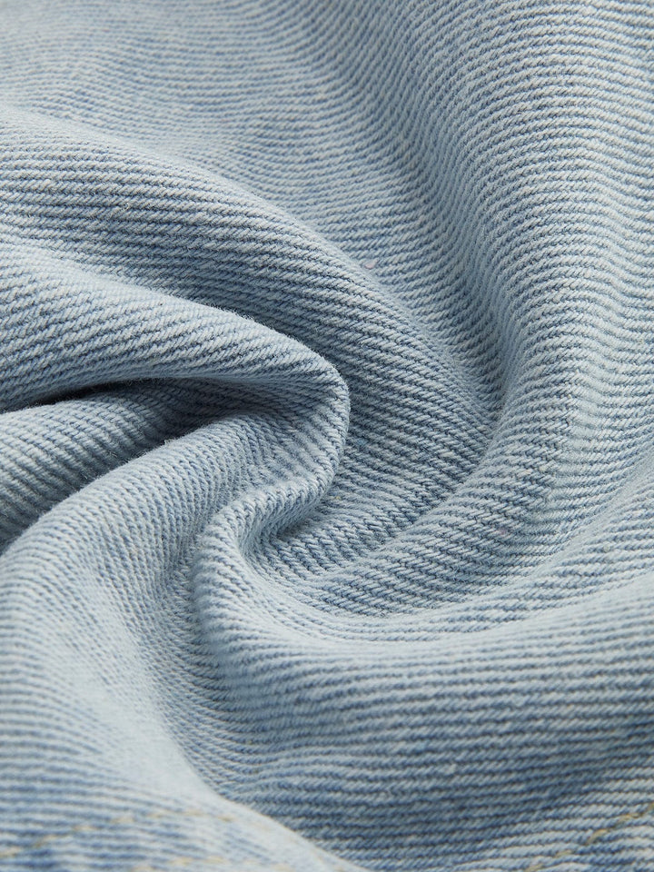Zoom sur le tissu en denim bleu clair de la veste en jean courte Clementine. Ce denim de haute qualité présente une texture douce et légèrement texturée, parfaite pour une coupe moderne et confortable. Le tissu, à la fois léger et résistant, est idéal pour un look casual élégant et décontracté.