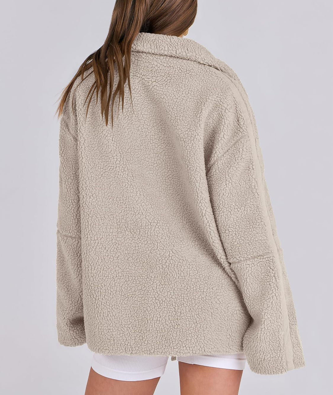 Veste en tissu peluche beige clair pour femme, vue de dos. Modèle doux et chaud à la texture duveteuse, avec une coupe oversize et un col montant. Son design simple et moderne apporte un style décontracté et élégant, parfait pour la saison automne-hiver.