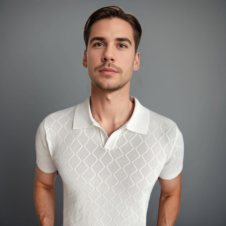 Homme portant un polo tricoté blanc à motif losange, avec un col à revers élégant. Un look moderne et sophistiqué, parfait pour des occasions décontractées ou habillées.