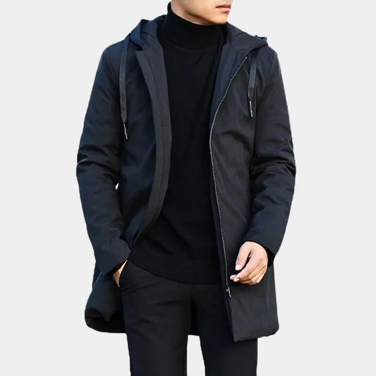Man dressed in a black long coat with a hood and a zipper, paired with a black turtleneck sweater, perfect for winter styling.