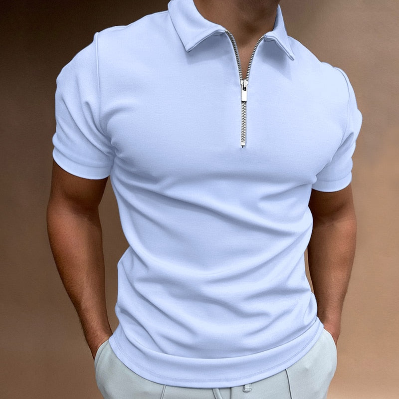 Polo pour homme bleu clair à manches courtes, coupe ajustée et contemporaine, avec col structuré et fermeture zippée, porté avec un pantalon clair pour un look élégant et moderne.