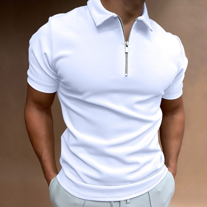 Polo pour homme blanc à manches courtes, coupe ajustée et moderne, doté d’un col avec fermeture zippée, porté avec un pantalon clair pour un style élégant, minimaliste et contemporain.