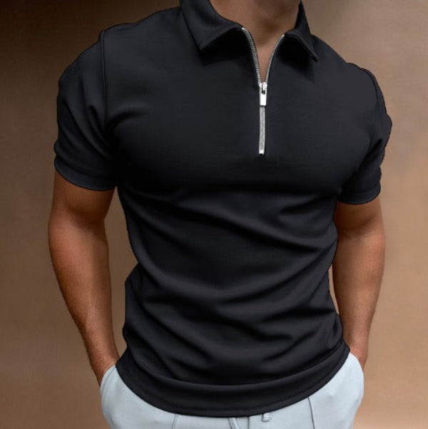 Polo pour homme noir à manches courtes, coupe ajustée et moderne, avec col structuré et fermeture zippée, porté avec un pantalon clair pour un style élégant, sobre et contemporain.