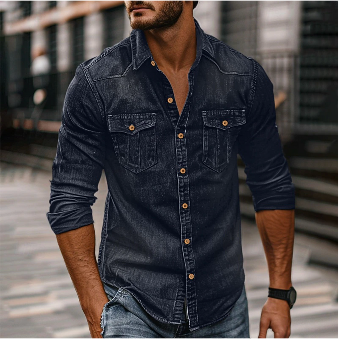 Homme portant la chemise moderne Étienne à manches longues en denim bleu foncé, coupe ajustée, boutons contrastés et deux poches poitrine, look casual urbain.