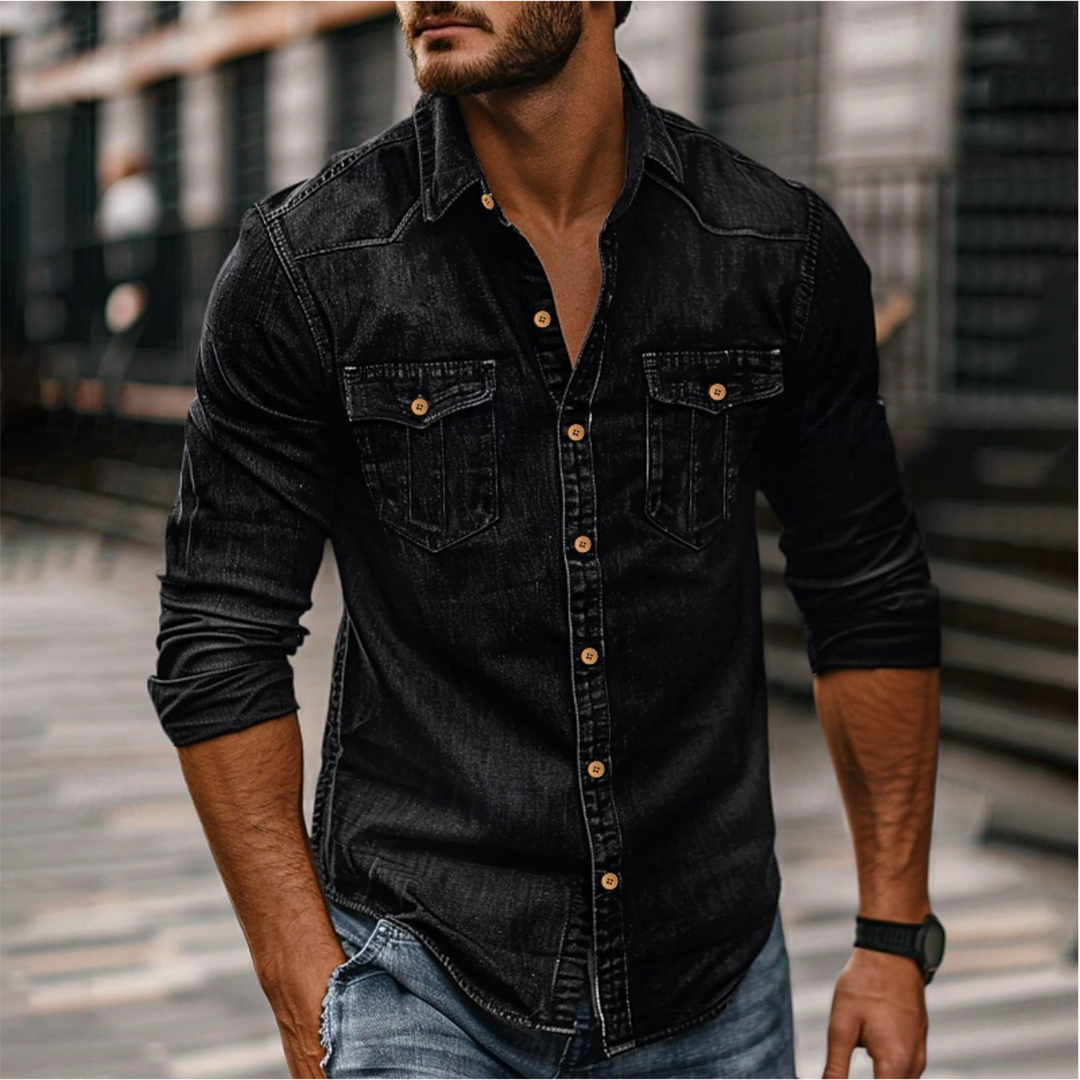 Homme portant la chemise moderne Étienne à manches longues en denim noir, coupe ajustée, boutons contrastés et deux poches poitrine, look casual urbain.