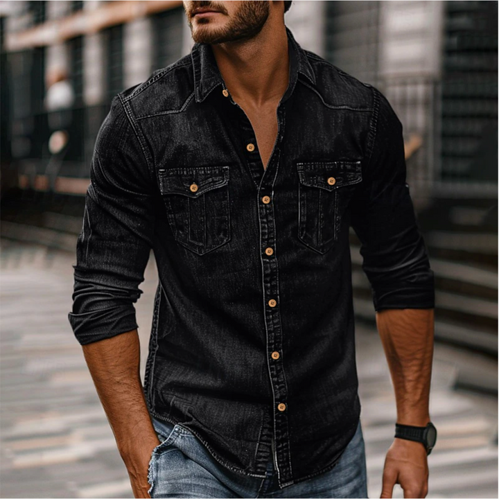 Homme portant la chemise moderne Étienne à manches longues en denim noir, coupe ajustée, boutons contrastés et deux poches poitrine, look casual urbain.
