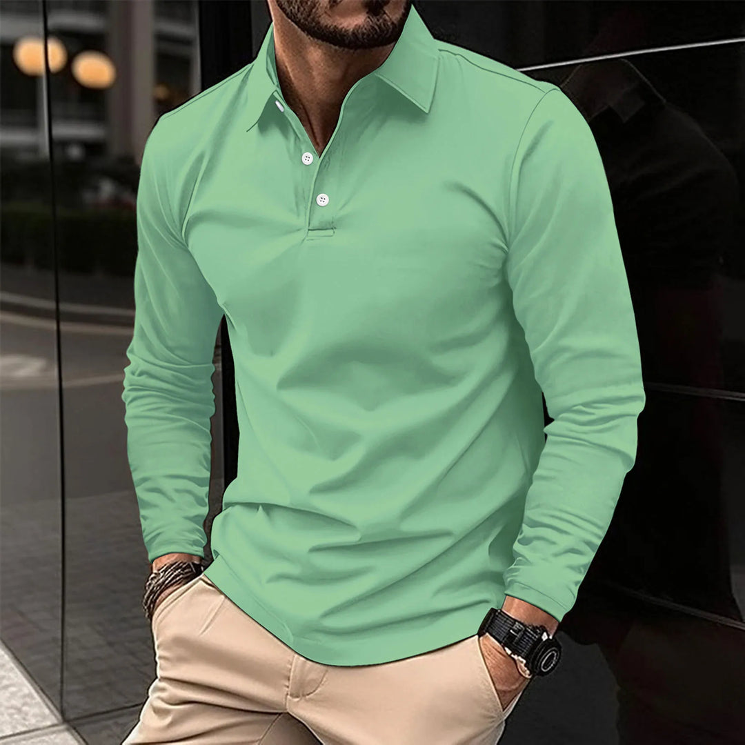 Polo à manches longues pour homme Eugène, coupe ajustée et moderne, en tissu doux vert menthe avec col classique et patte de boutonnage, porté avec un pantalon beige pour un look élégant et tendance.