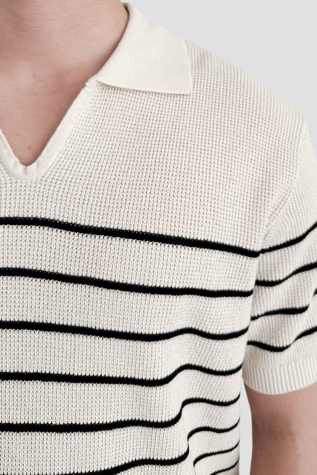 Polo à manches courtes pour homme Felix, tricoté en maille fine avec rayures noires horizontales sur fond blanc, col classique, style tendance et décontracté.