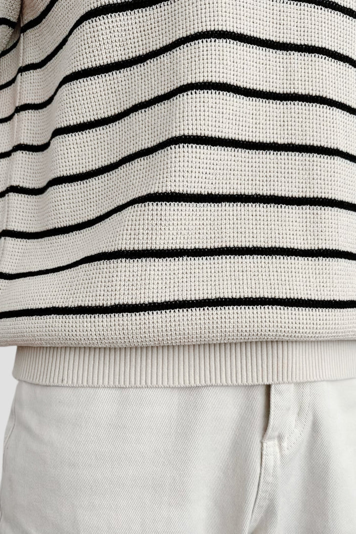 Polo à manches courtes pour homme Felix, tricoté en maille crème avec fines rayures noires horizontales, vue rapprochée sur le bas du vêtement et la taille, style tendance et moderne.