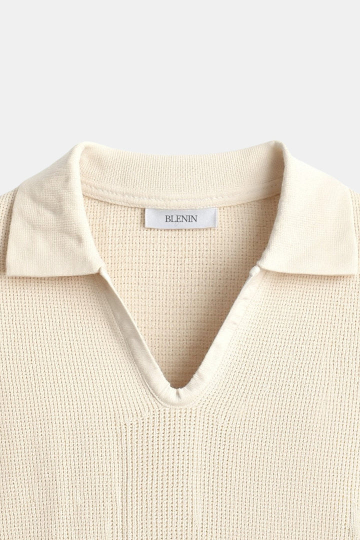 Felix Polo à manches courtes pour homme, col V avec col classique, tricot beige avec fines rayures noires, style tendance et moderne, vue rapprochée sur le col et la partie supérieure du polo.
