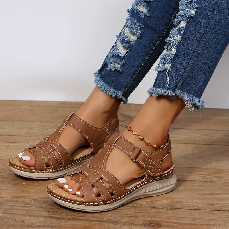 Sandales femme marron style gladiateur avec brides croisées et fermeture à scratch, semelle plate confortable et look moderne pour l’été.