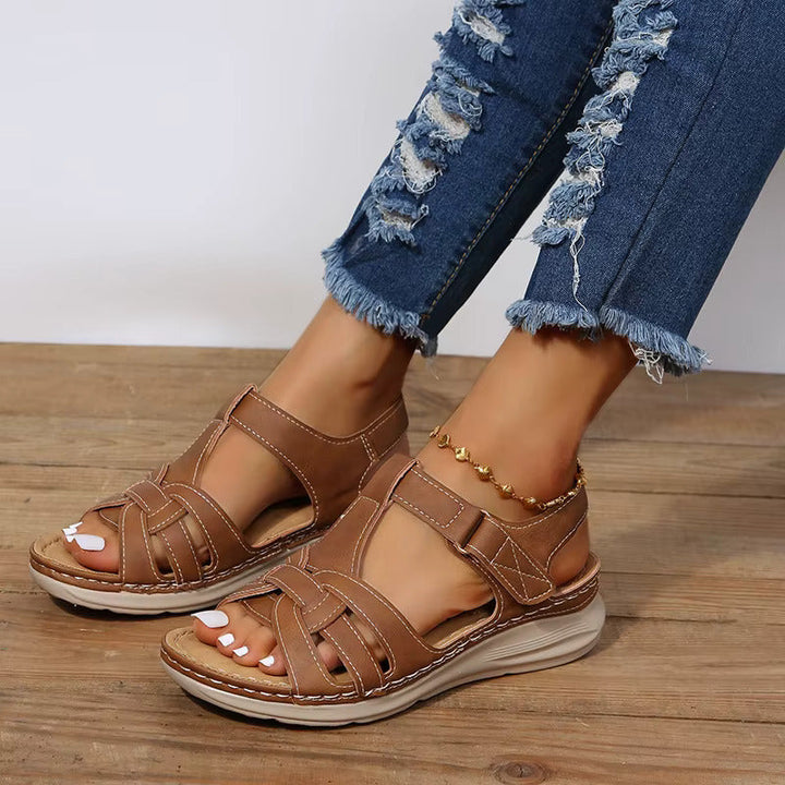Sandales femme marron style gladiateur avec brides croisées et fermeture à scratch, semelle plate confortable et look moderne pour l’été.