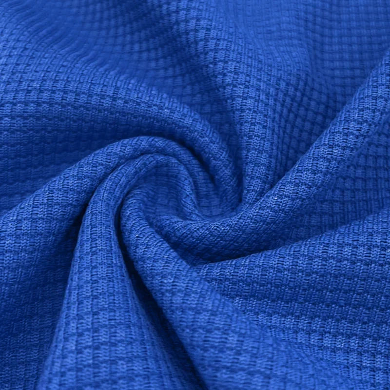 Zoom sur le tissu du polo homme Firmin, en maillage texturé de couleur bleue. Le tissu offre une texture légère et respirante, idéale pour le confort et la durabilité, tout en apportant une touche de sophistication à votre look.