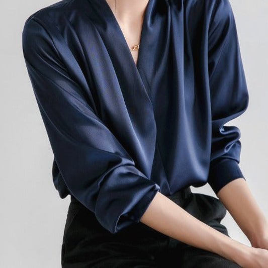 Blouse satinée bleu marine à col en V croisé, manches longues élégantes, coupe fluide et sophistiquée parfaite pour le bureau ou une tenue habillée.