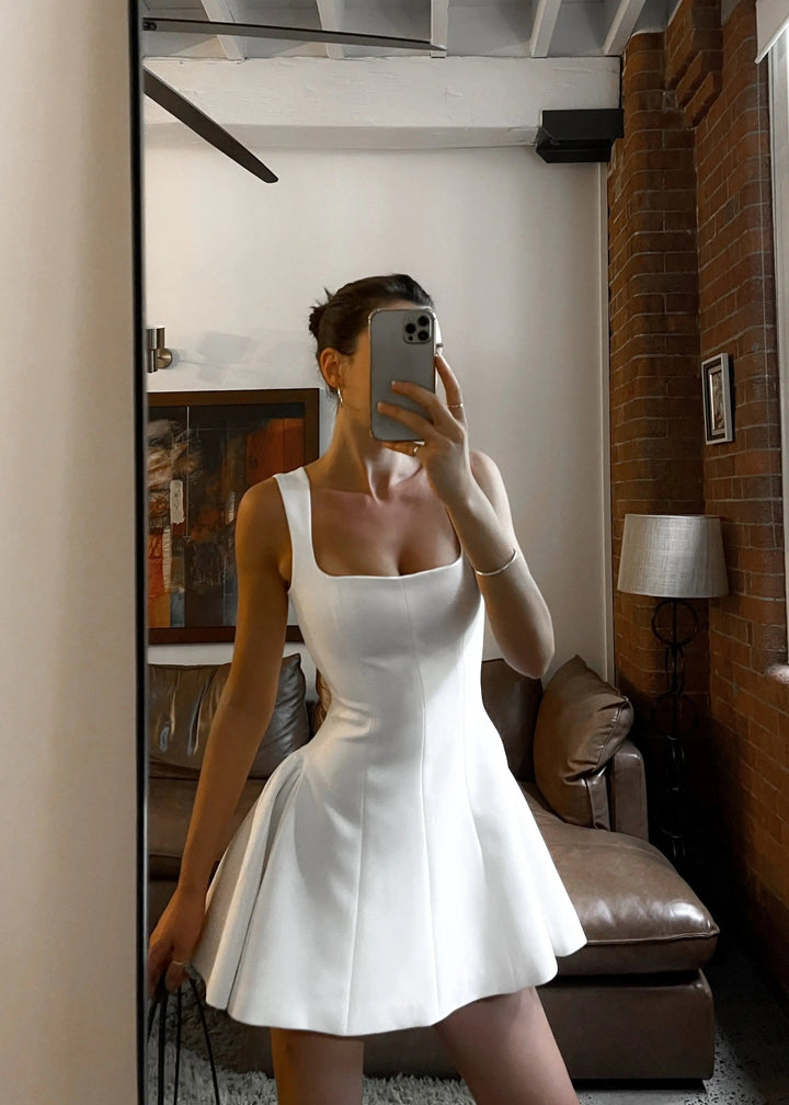 Robe mini femme tendance, parfaite pour un look chic et moderne. Avec son décolleté carré et sa coupe évasée, cette robe blanche met en valeur la silhouette. Idéale pour vos sorties élégantes, elle s'associe parfaitement à un sac pour compléter votre tenue.