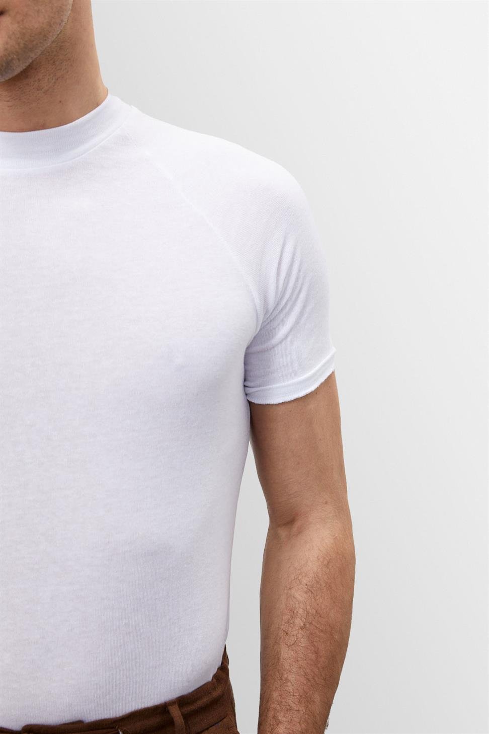 Détail du t-shirt blanc slim fit pour homme Frédéric, coupe ajustée près du corps, en tissu doux et extensible avec col rond, idéal pour un style moderne et épuré.