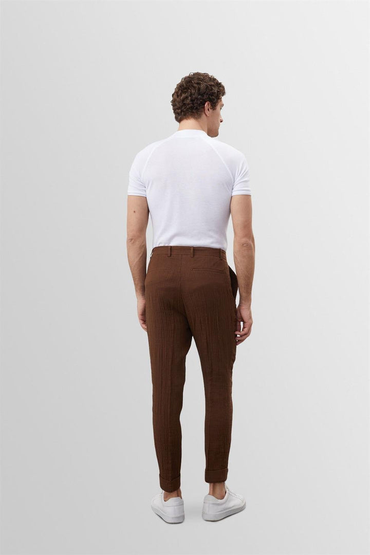 Vue arrière du t-shirt blanc slim fit pour homme Frédéric, coupe ajustée mettant en valeur la silhouette, en tissu doux et extensible, porté avec un pantalon marron pour un style moderne et épuré.