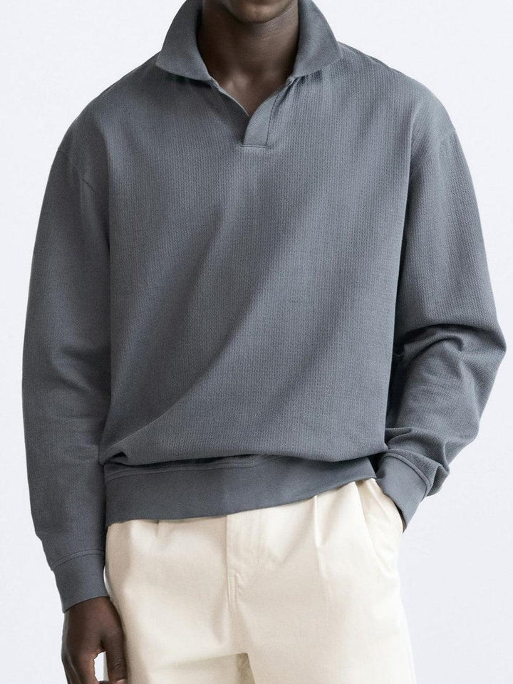 Polo à manches longues pour homme Gaspard en gris, avec col ouvert et coupe moderne, offrant un style élégant, minimaliste et confortable au quotidien.
