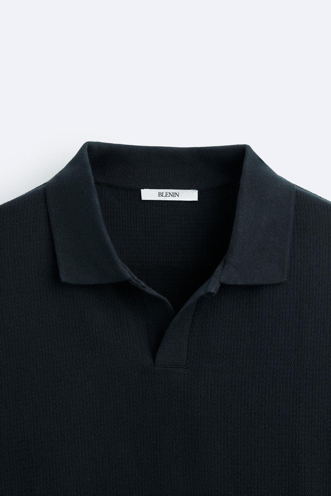 Détail du col du polo à manches longues pour homme Gaspard en noir, avec col structuré et coupe moderne, offrant un style élégant et contemporain.