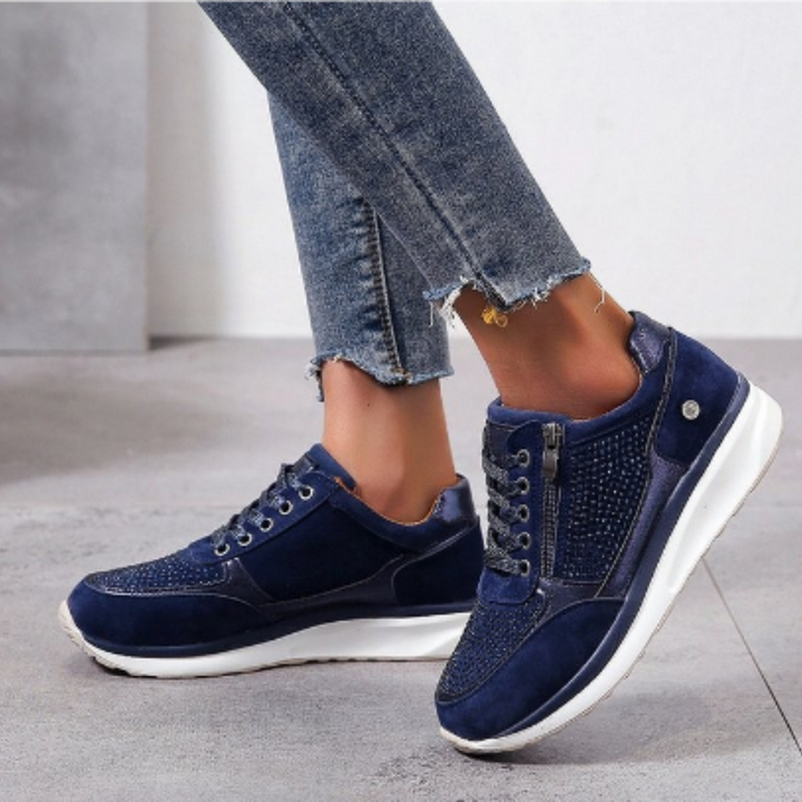 Chaussures pour femme en bleu marine, avec un design moderne et élégant. Elles sont ornées de strass sur le dessus et d'une fermeture éclair sur le côté, offrant à la fois confort et praticité. Parfaites pour un look décontracté, tout en restant stylées et tendance.