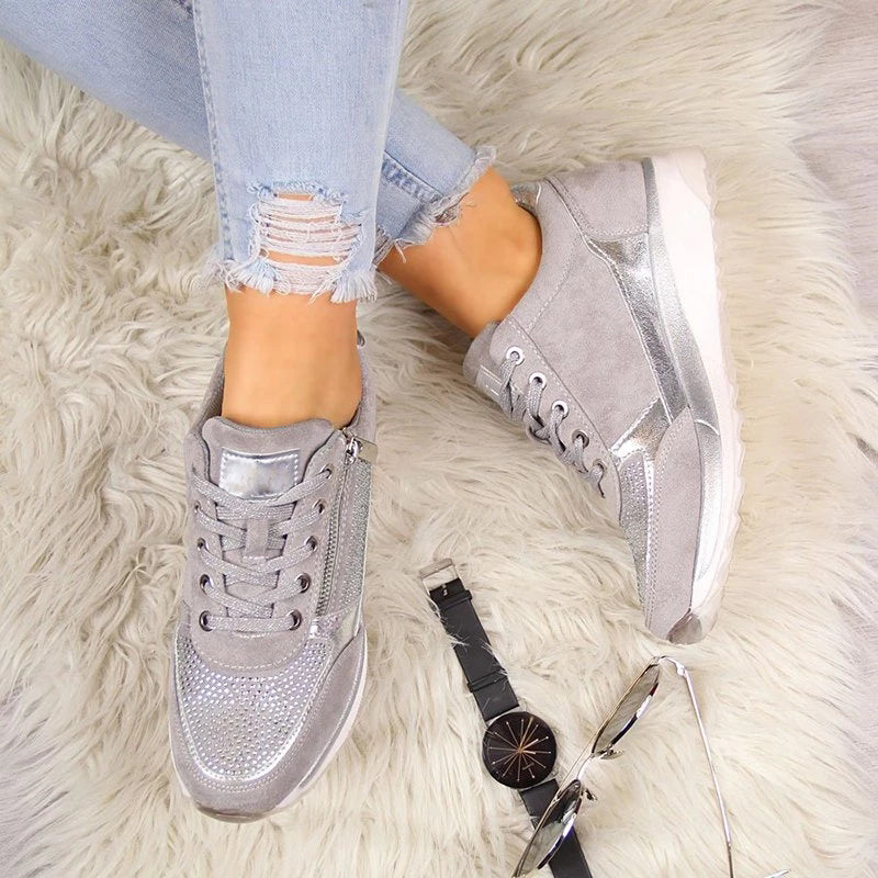 Chaussures pour femme argentées avec des détails métallisés, associant confort et modernité. Elles sont dotées d'une fermeture éclair pratique sur le côté et sont parfaites pour un look tendance et décontracté. Accessoirisées avec une montre et des lunettes de soleil, idéales pour compléter une tenue stylée.
