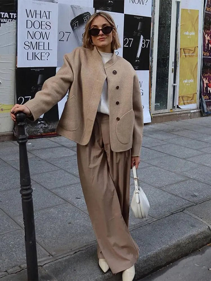 Veste courte pour femme en tissu chaud, idéale pour l'hiver. Son design moderne et élégant, avec des boutons contrastés et des poches arrondies, offre un look chic et intemporel. Parfaite pour les journées fraîches, cette veste se marie facilement avec des pantalons larges ou des jupes, apportant confort et style à vos tenues hivernales.