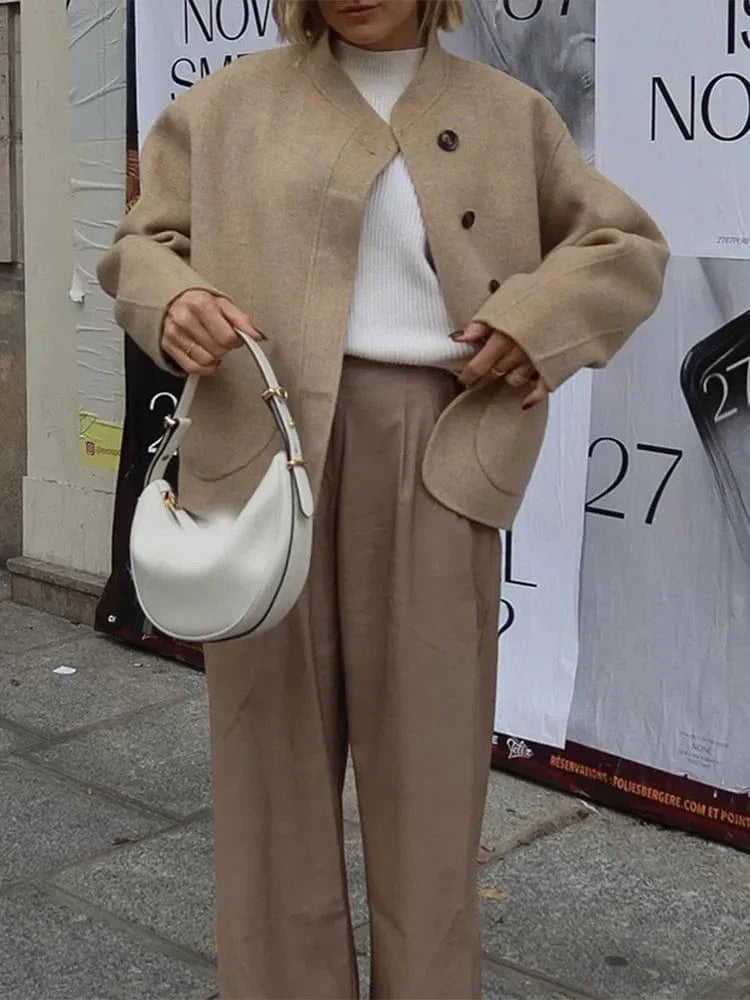 Veste courte pour femme en laine douce, parfaite pour les journées froides de l'hiver. Avec ses boutons élégants et ses poches arrondies, elle offre un look chic et décontracté. Son design moderne se marie parfaitement avec des pantalons larges ou une jupe, pour une tenue stylée et confortable pendant la saison hivernale.