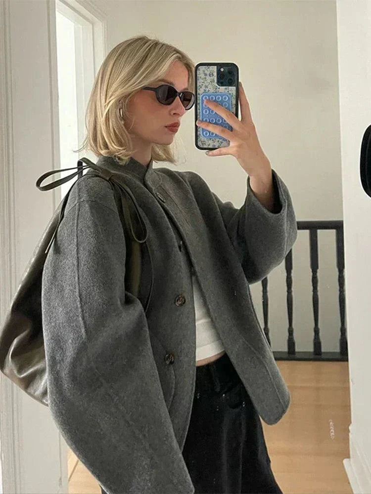 Veste courte pour femme en laine gris clair, idéale pour l'hiver. Avec ses boutons élégants et son design moderne, cette veste offre une silhouette chic et décontractée. Elle se porte facilement avec un pull ou un t-shirt, apportant confort et chaleur pendant les journées fraîches tout en restant stylée.