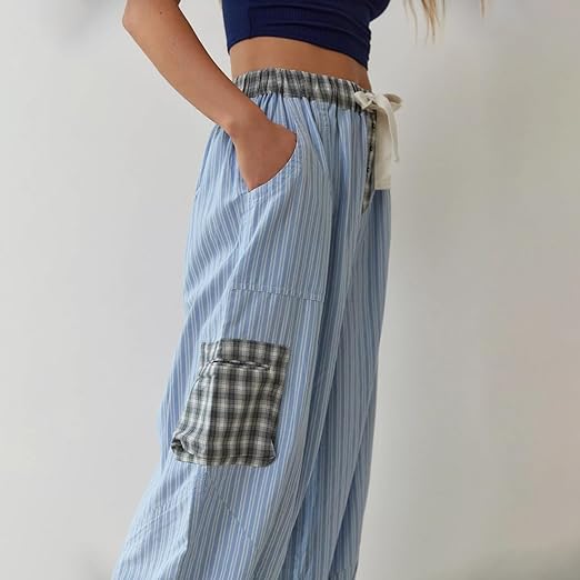Pantalon de pyjama pour femme à coupe ample, en tissu bleu clair à fines rayures, avec taille élastique et cordon de serrage, poches latérales et poche plaquée à carreaux pour un style confortable et tendance.