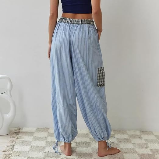Pantalon de pyjama pour femme vu de dos, à coupe ample, en tissu bleu clair à fines rayures, avec taille élastique, bas resserrés par liens et poche à carreaux sur le côté, pour un confort moderne à la maison.