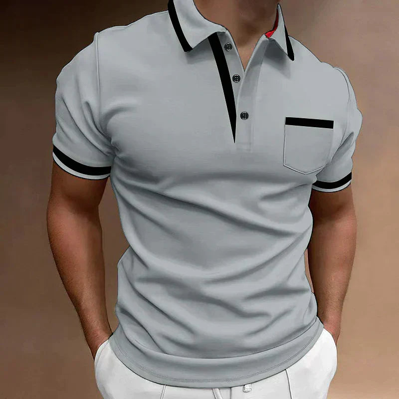 Polo homme moderne gris clair avec col et détails noirs contrastés, patte de boutonnage élégante et poche poitrine discrète, coupe ajustée pour un style à la fois chic et décontracté.