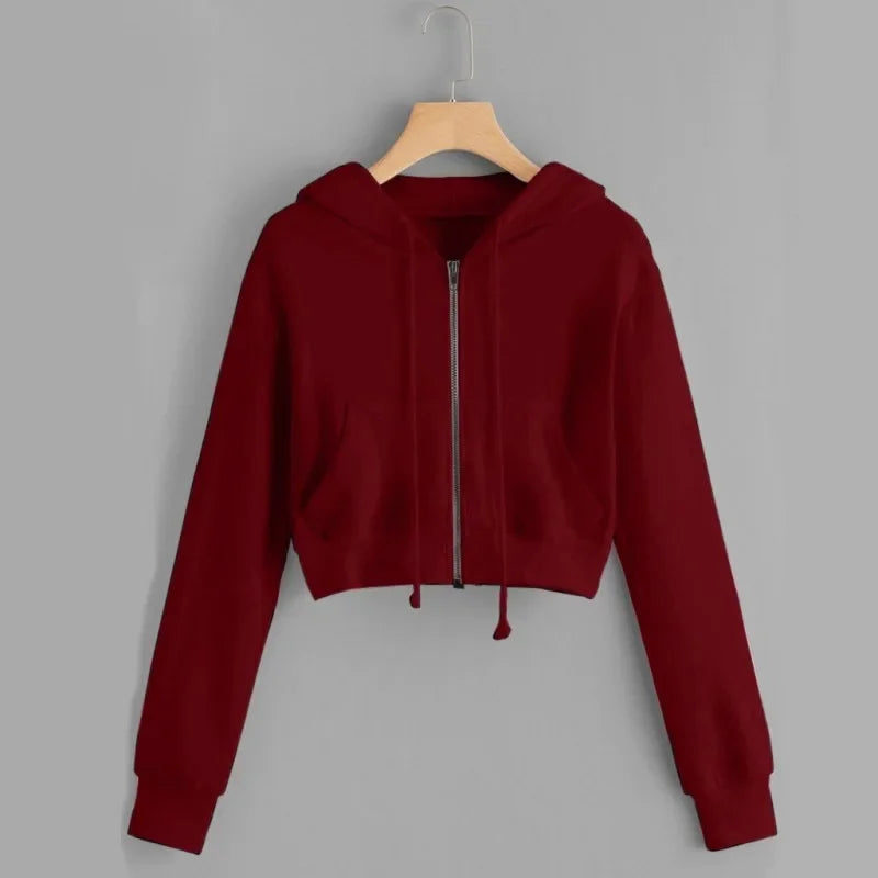 Un sweat à capuche rouge bordeaux avec une fermeture éclair à l'avant. Ce modèle court possède des manches longues et une coupe ajustée, parfait pour un look décontracté et stylé.