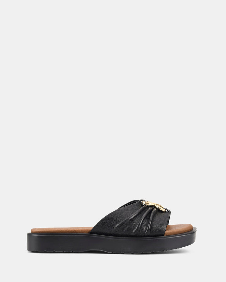 Sandales noires à semelle ondulée pour femmes, modèle Ivoiry. Design moderne avec un élégant détail de boucle dorée et une coupe confortable, parfaite pour un look chic et décontracté.