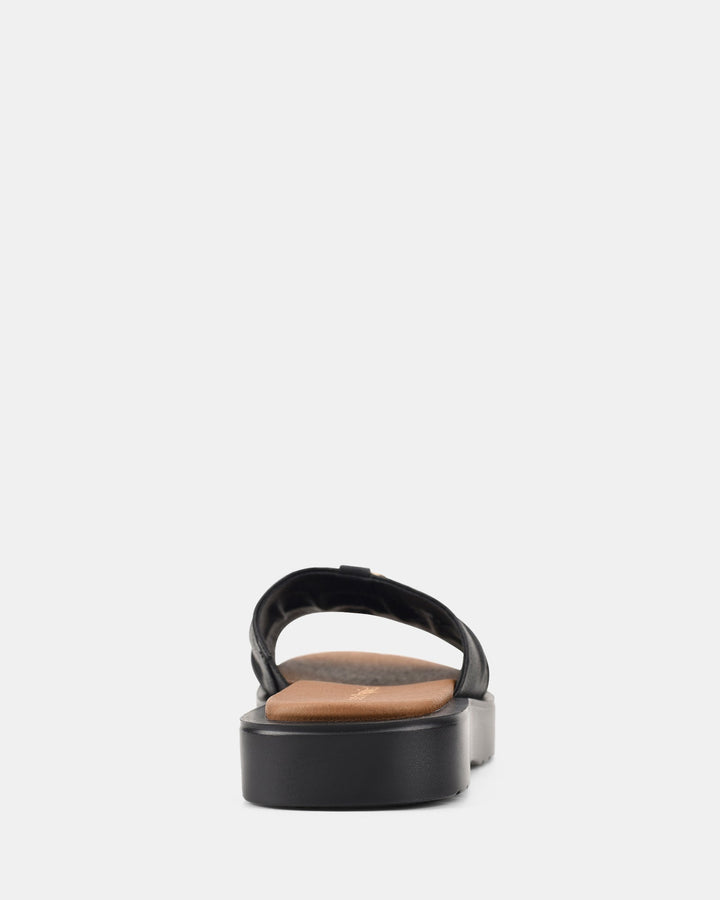 Vue arrière des sandales noires à semelle ondulée pour femmes, modèle Ivoiry. Design moderne avec une bride élégante et une semelle confortable pour un look chic et décontracté.
