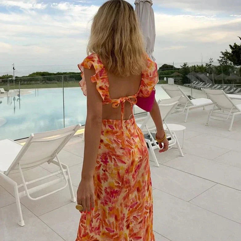 Vue arrière de la Jade Robe longue à motif floral pour femme, avec un dos nu et des volants féminins. Cette robe aux couleurs vives et estivales est idéale pour des moments de détente au bord de la piscine ou pour toute occasion décontractée et stylée.